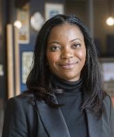 Olaide Oboh Olaide Oboh - a woman wearing a black roll neck and suit jacket smiles at the camera
