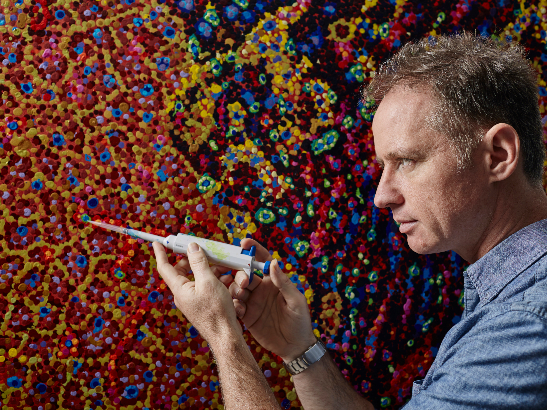James Cochran Cell Defence 188 547x410 Artist James Cochran posing with a laboratory pipette in front of his painting 'Cell Defence'